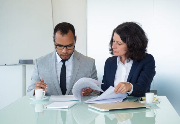 Business colleagues checking agreement text Intellectual Property Damage Expert