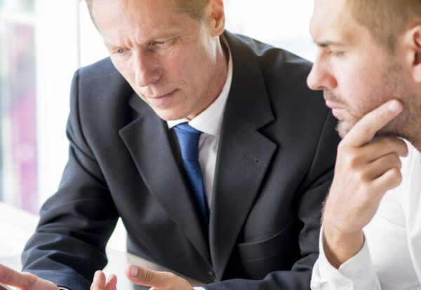 two-businessman-discussing-business-plan-digital-tablet Patent economic valuation